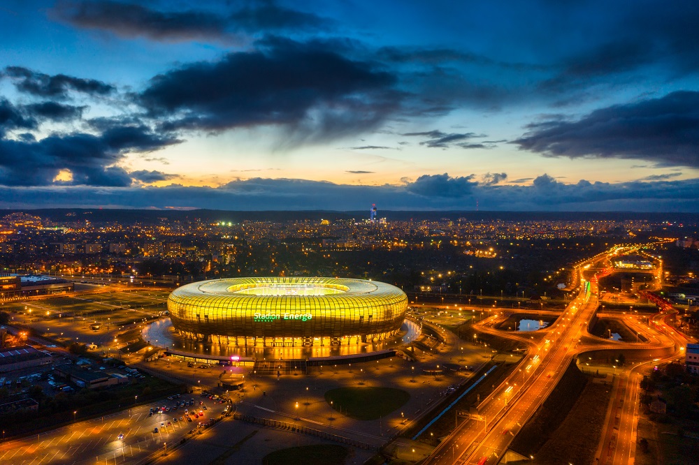 Widok z góry nocą na oświetlony stadion Polsat Plus Arena Gdańsk